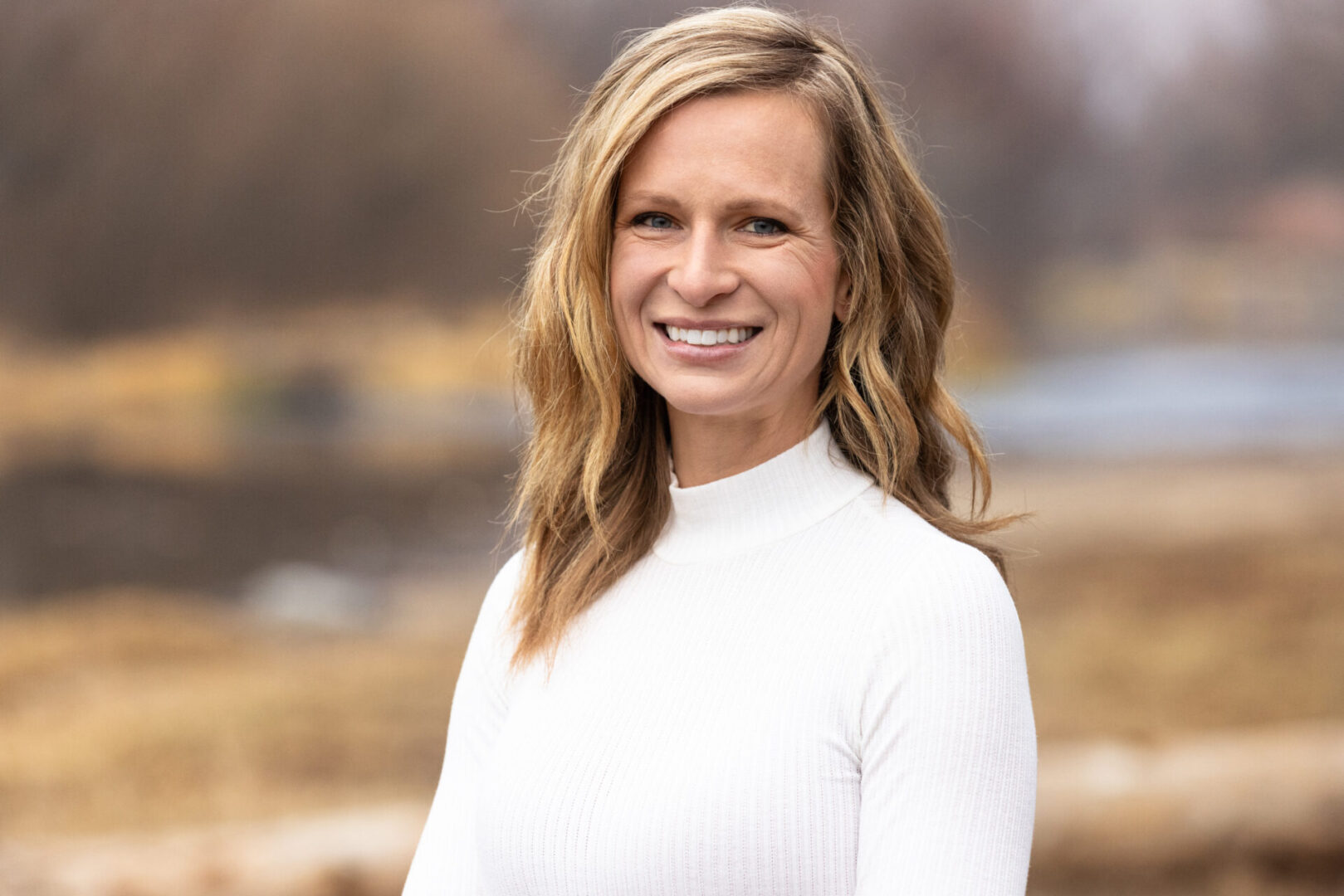 A woman in white shirt smiling for the camera.